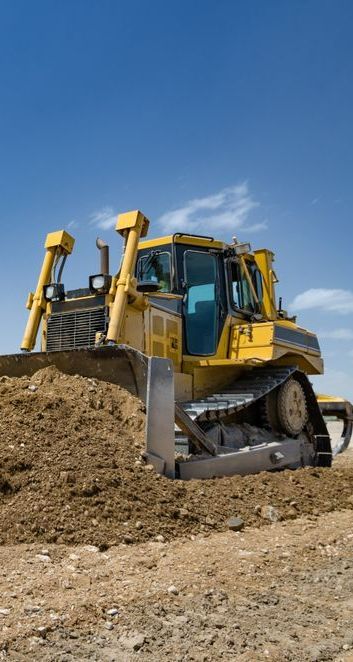 A Yellow Bulldozer is Moving Dirt on a Construction Site — Copp & Co Civil & Plant Hire in Cannonvale, QLD