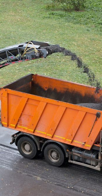 A Dump Truck is Being Loaded With Dirt by a Crane — Copp & Co Civil & Plant Hire in Bowen, QLD