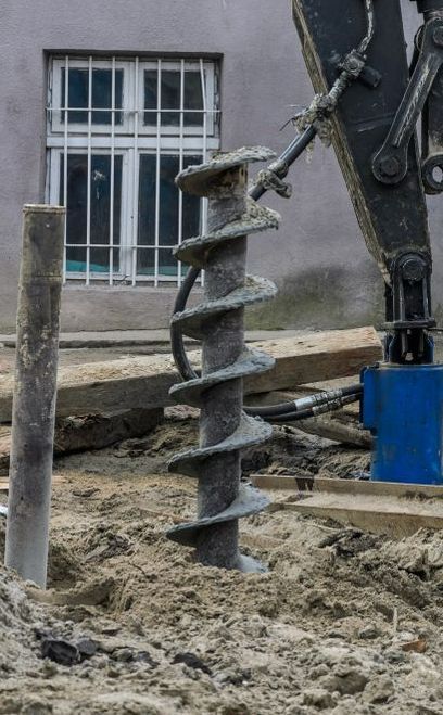 A Large Drill Bit is Being Used to Dig a Hole in the Ground — Copp & Co Civil & Plant Hire in Cannonvale, QLD