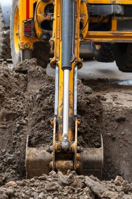 A Yellow Excavator is Digging a Hole in the Ground — Copp & Co Civil & Plant Hire in Proserpine, QLD