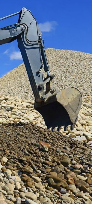 An Excavator is Digging in a Pile of Rocks — Copp & Co Civil & Plant Hire in Cannonvale, QLD