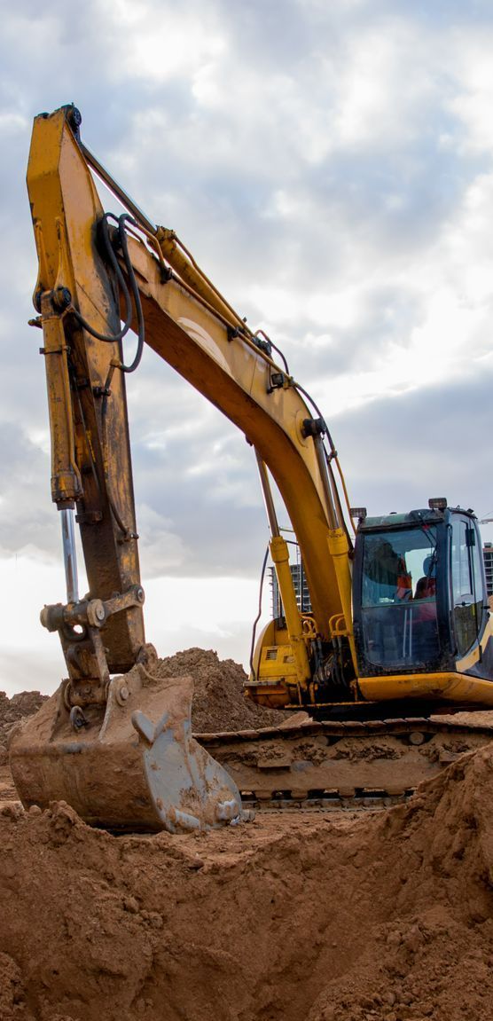 A Yellow Excavator is Digging a Hole in the Dirt — Copp & Co Civil & Plant Hire in Cannonvale, QLD