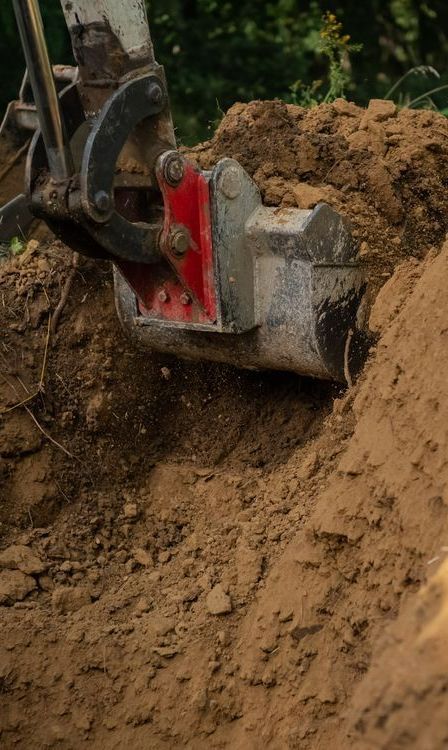 A Bulldozer is Digging a Hole in the Dirt — Copp & Co Civil & Plant Hire in Airlie Beach, QLD