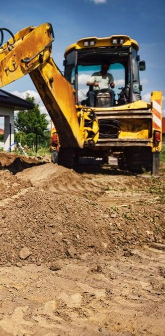 A Yellow Bulldozer is Digging a Hole in the Dirt — Copp & Co Civil & Plant Hire in Airlie Beach, QLD