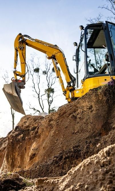 A Yellow Excavator is Digging a Hole in the Ground — Copp & Co Civil & Plant Hire in Airlie Beach, QLD