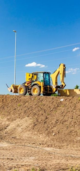 A Yellow Excavator is Sitting on Top of a Dirt Hill — Copp & Co Civil & Plant Hire in Cannonvale, QLD