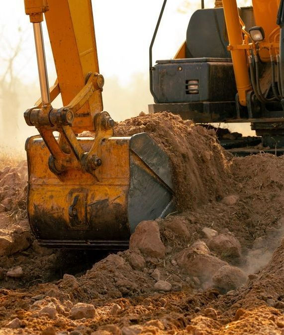 A Yellow Excavator is Digging a Hole in the Ground — Copp & Co Civil & Plant Hire in Airlie Beach, QLD