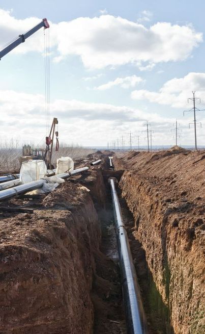 A Crane is Lifting a Pipe in a Trench — Copp & Co Civil & Plant Hire in Airlie Beach, QLD