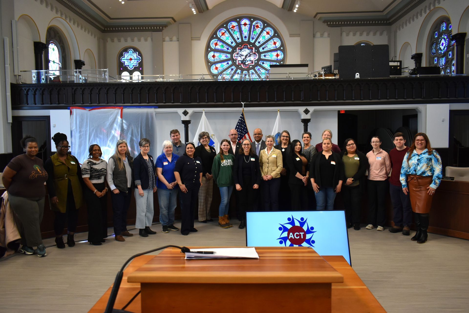 A group posing for photo, ACT logo on screen