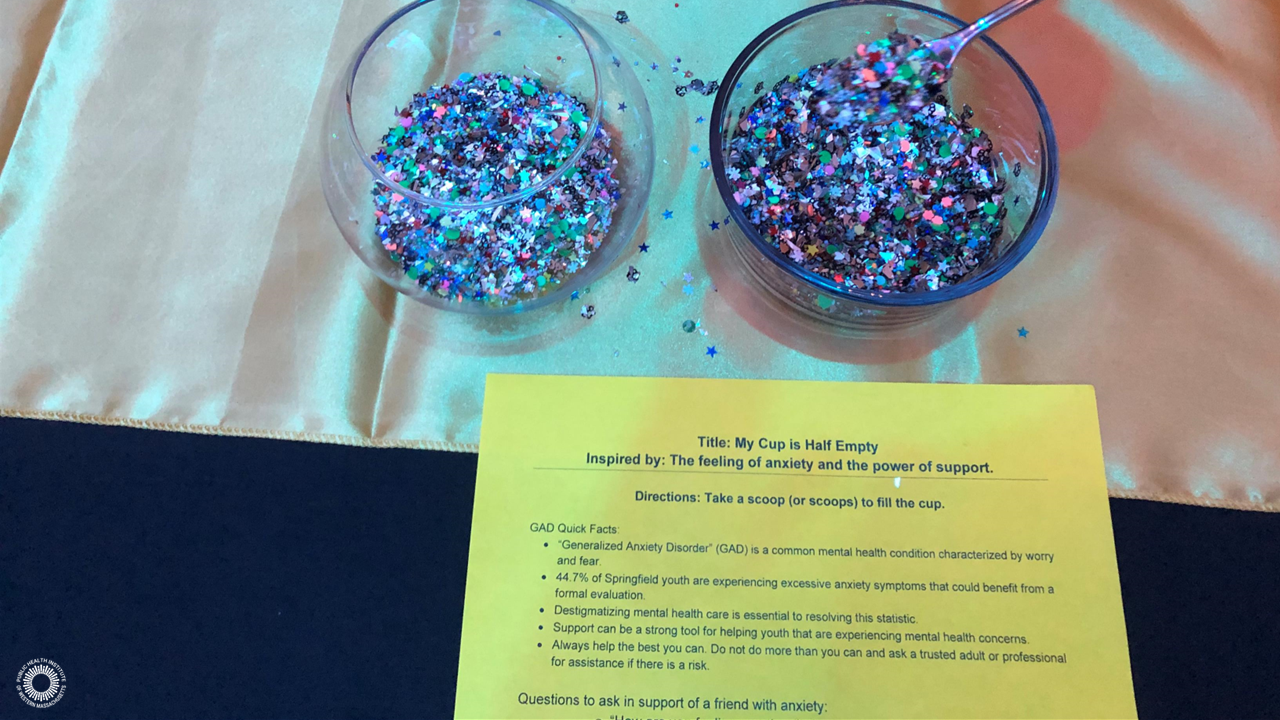 Two bowls of sparkly confetti next to paper that says, 