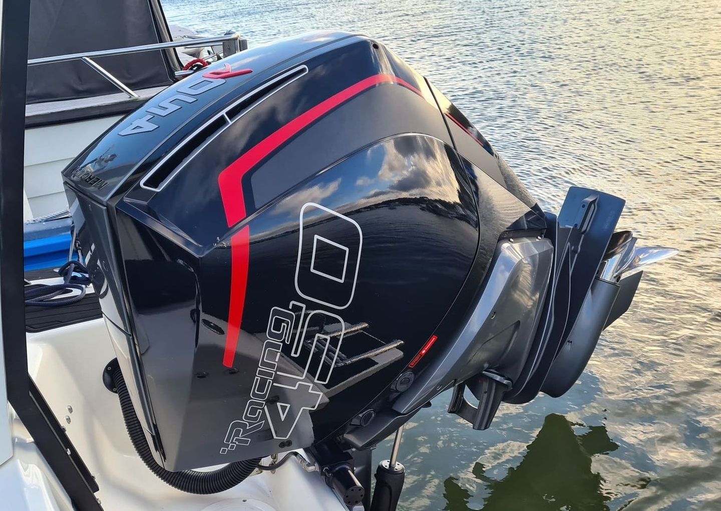 A black and red outboard motor is sitting on the side of a boat.