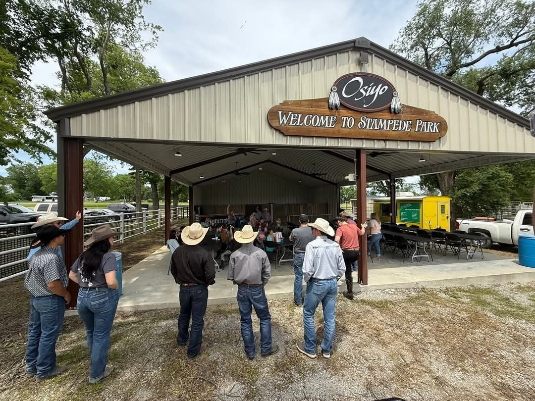 A group of people are standing in front of a pavilion.