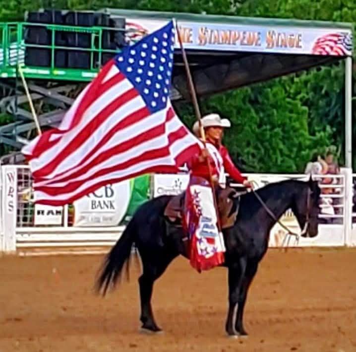 A man on a horse holding an american flag
