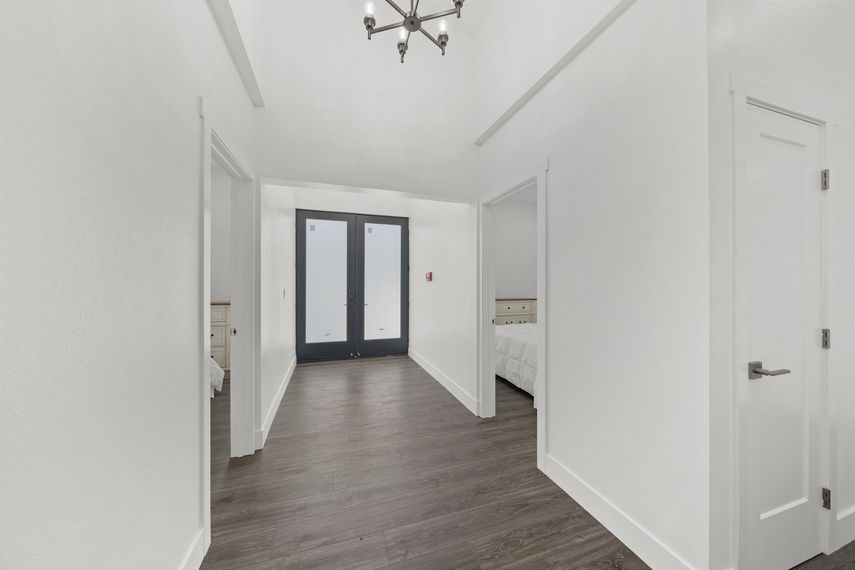 A hallway in a house with a chandelier hanging from the ceiling