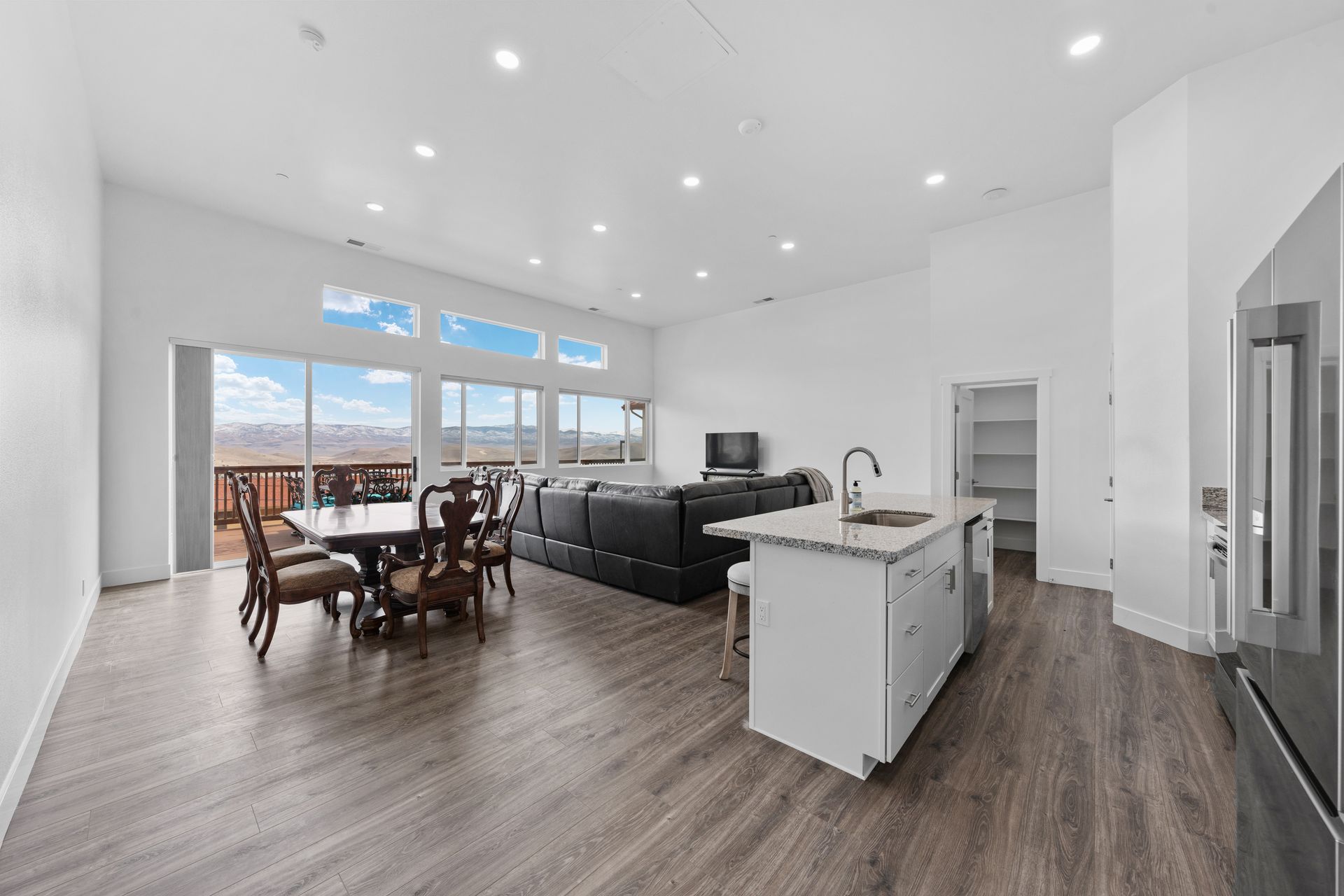 A large living room with a dining table and chairs and a kitchen.