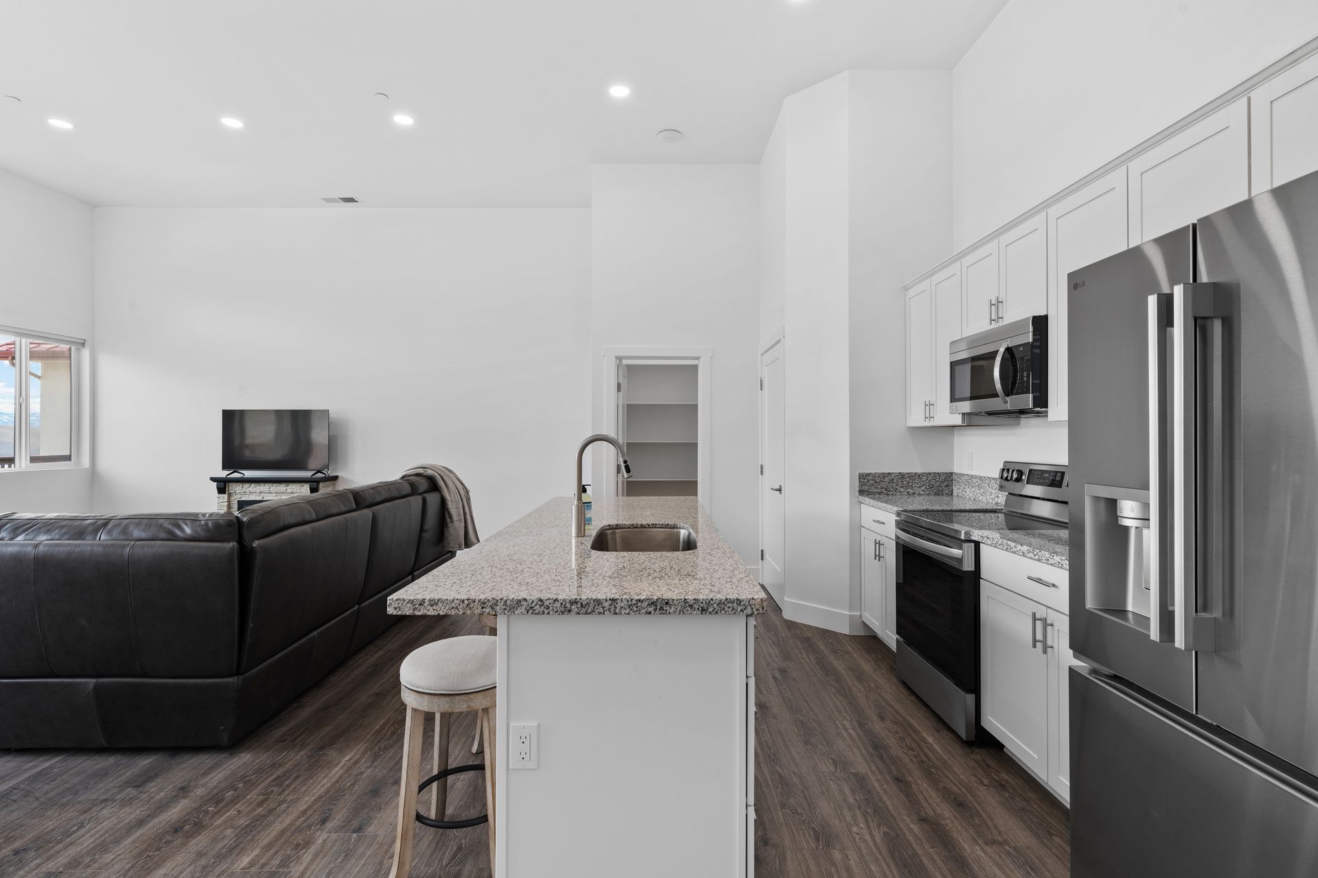 A kitchen with a stainless steel refrigerator , sink , stove and microwave.