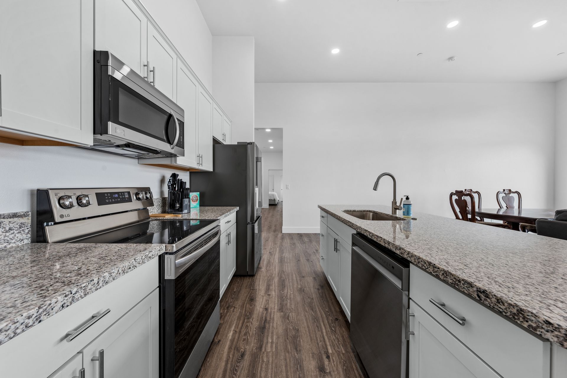 A kitchen with granite counter tops and stainless steel appliances.