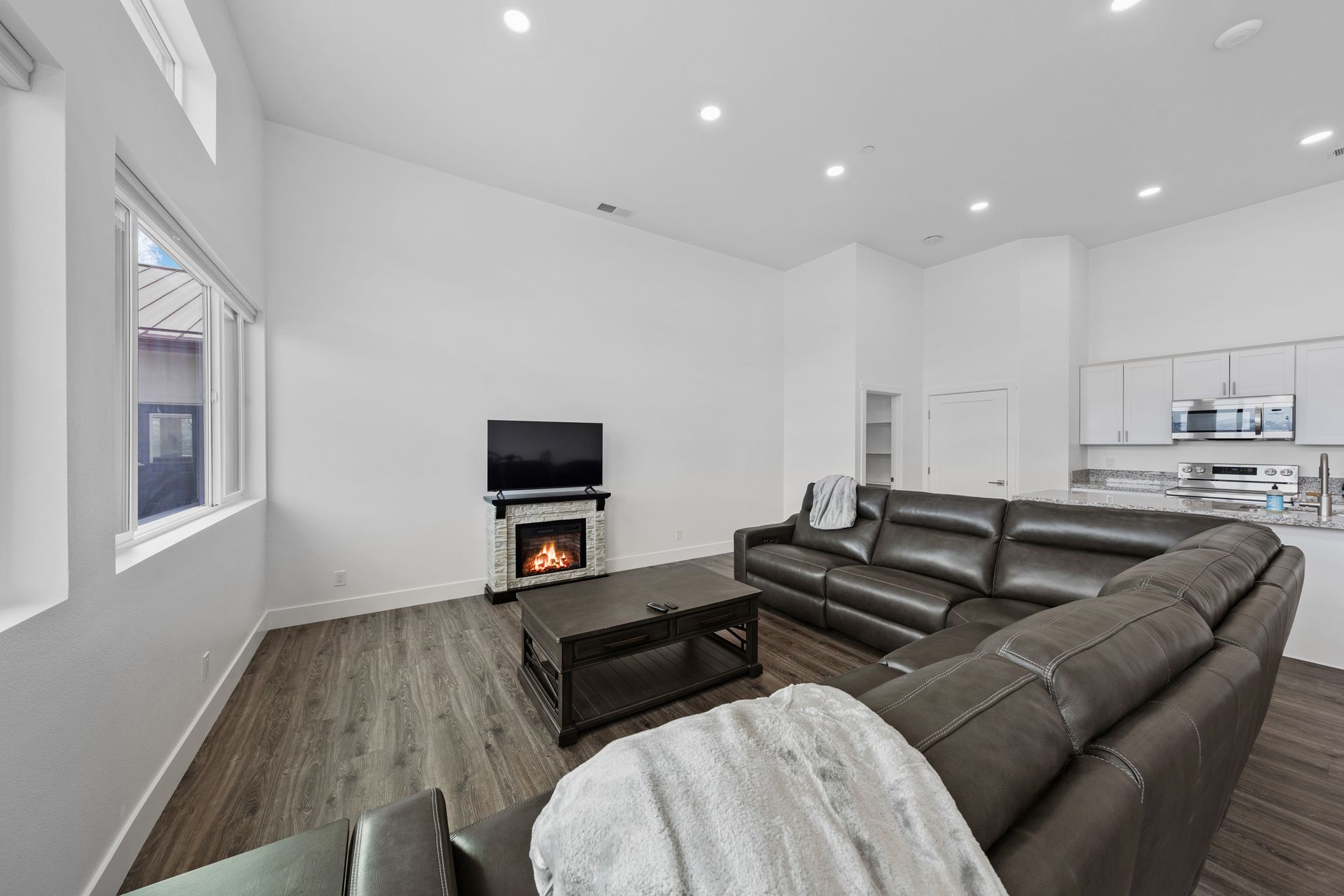 A living room with a large sectional couch and a fireplace.