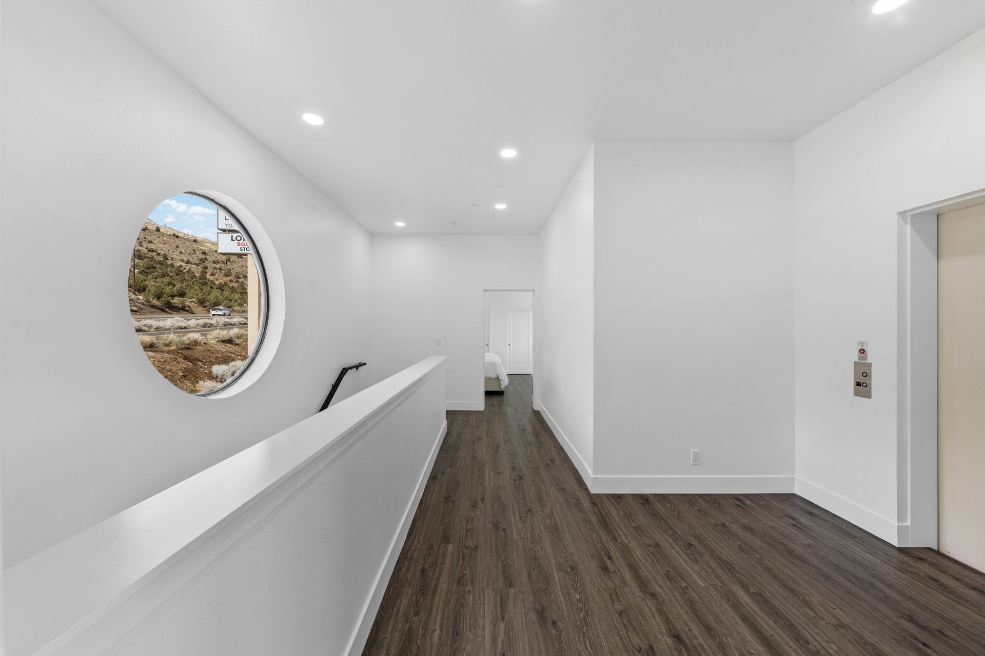 A long hallway with a round window in the middle of it.