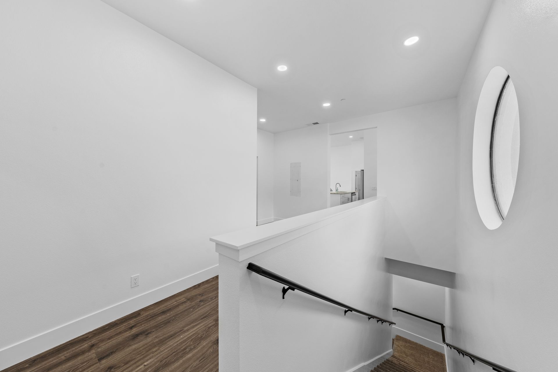 A hallway with stairs leading up to the second floor of a house.