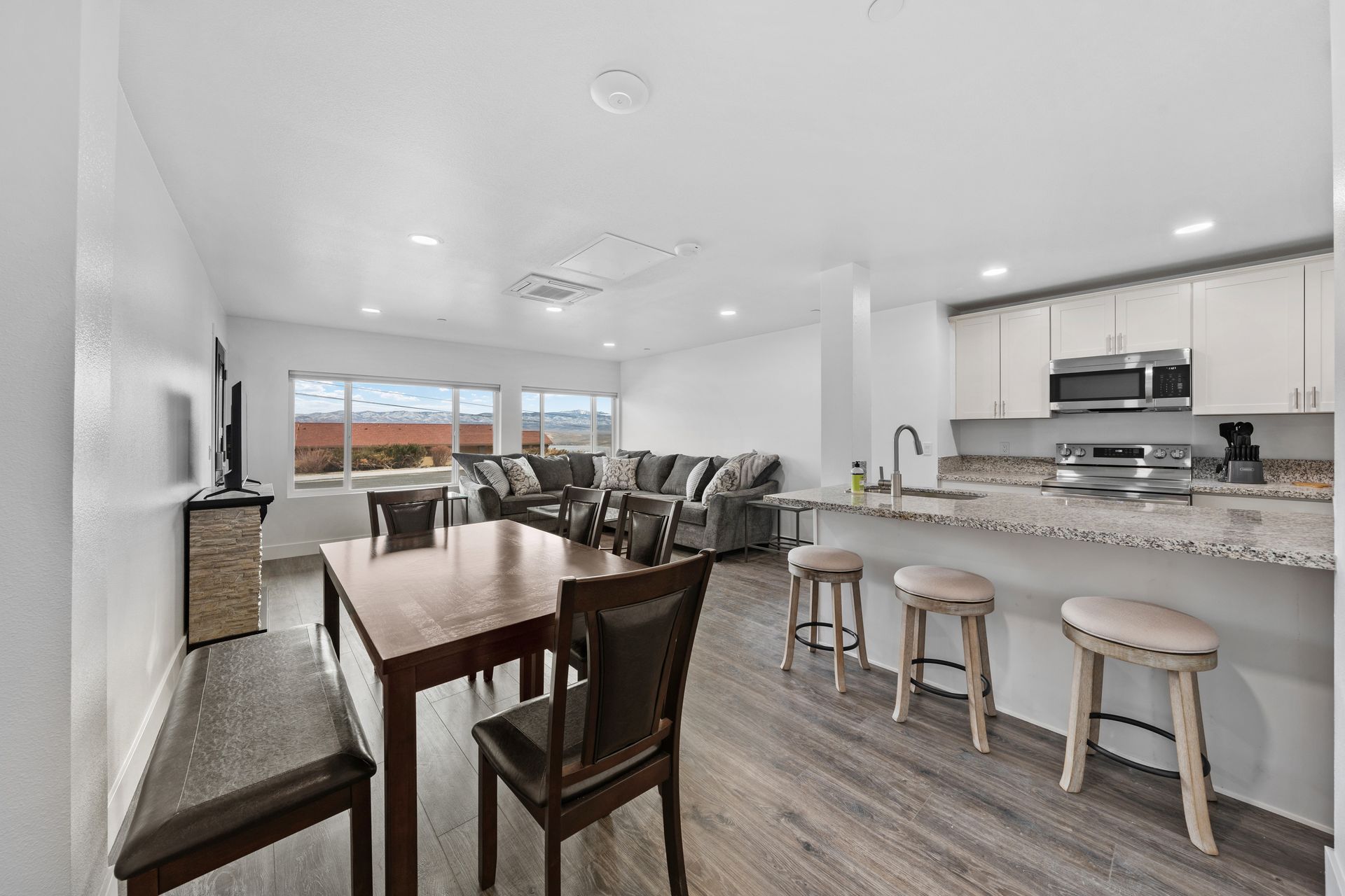 A living room with a dining table and chairs and a kitchen.