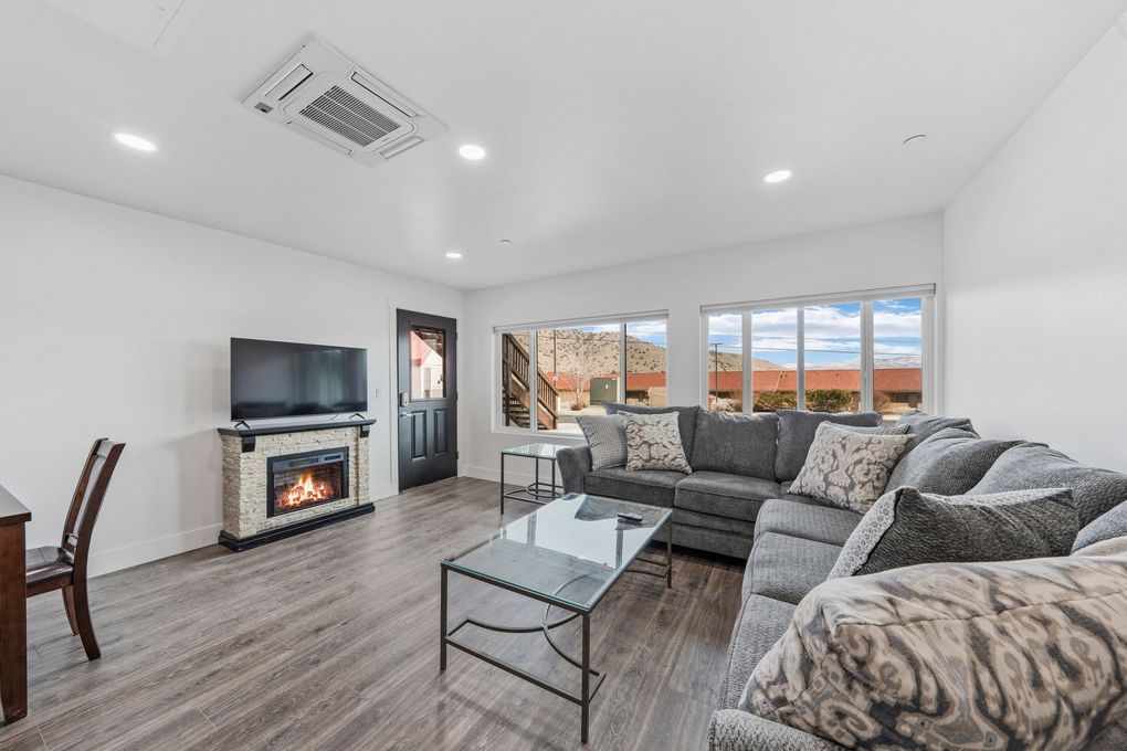 A living room with a couch , fireplace and television.