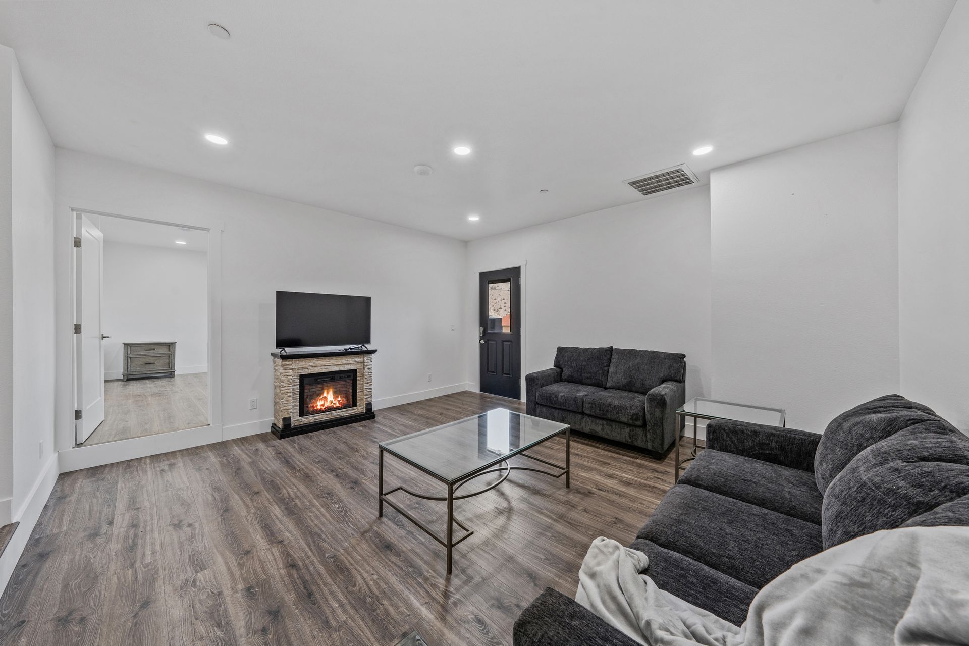 A living room with a couch , coffee table , fireplace and television.