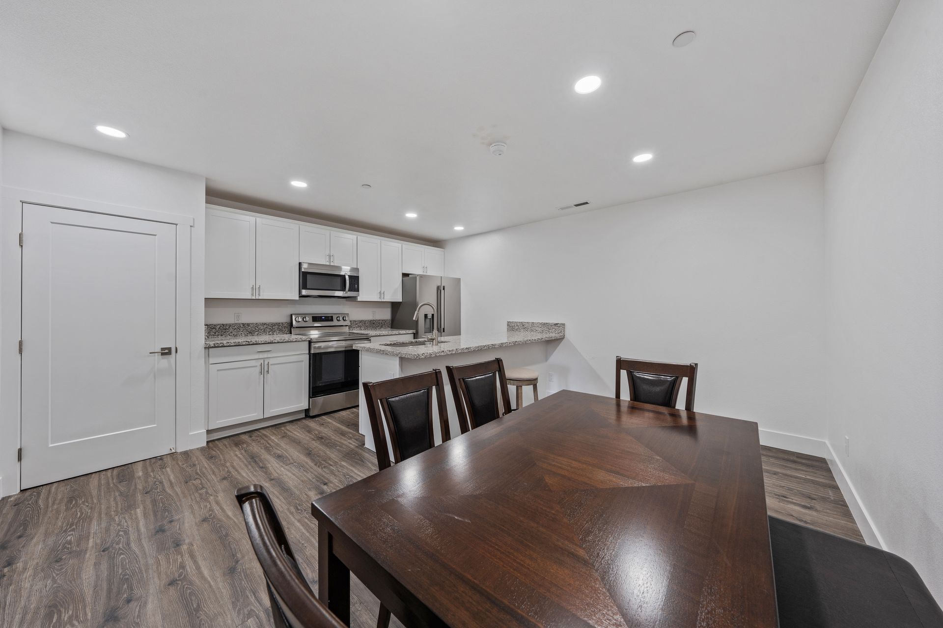 A dining room table and chairs in a kitchen.