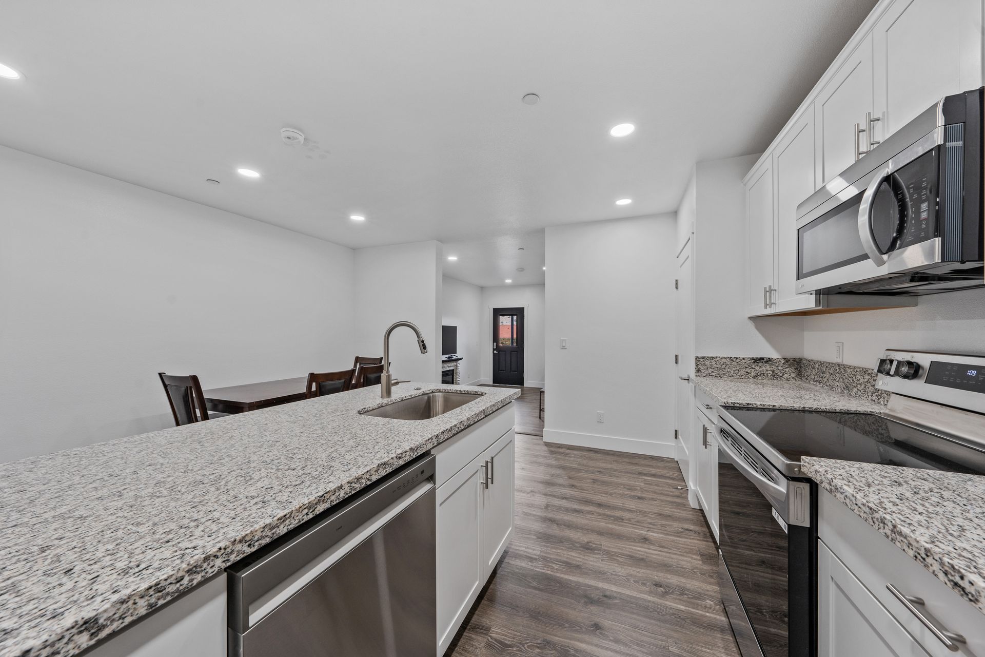 A kitchen with granite counter tops and stainless steel appliances.