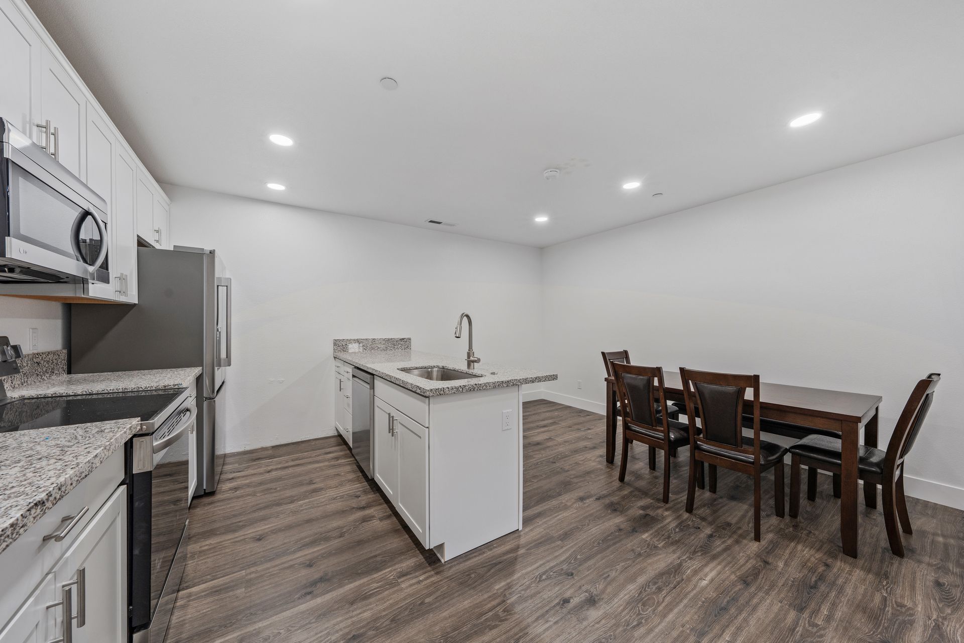 A kitchen with a dining table and chairs in it.