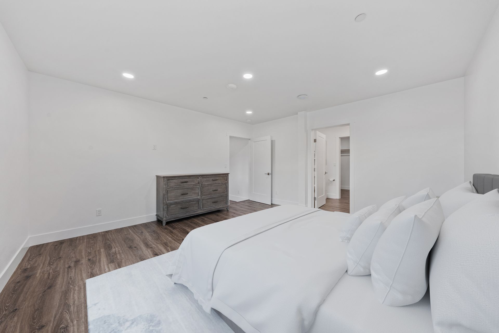 A bedroom with a large bed and a dresser.