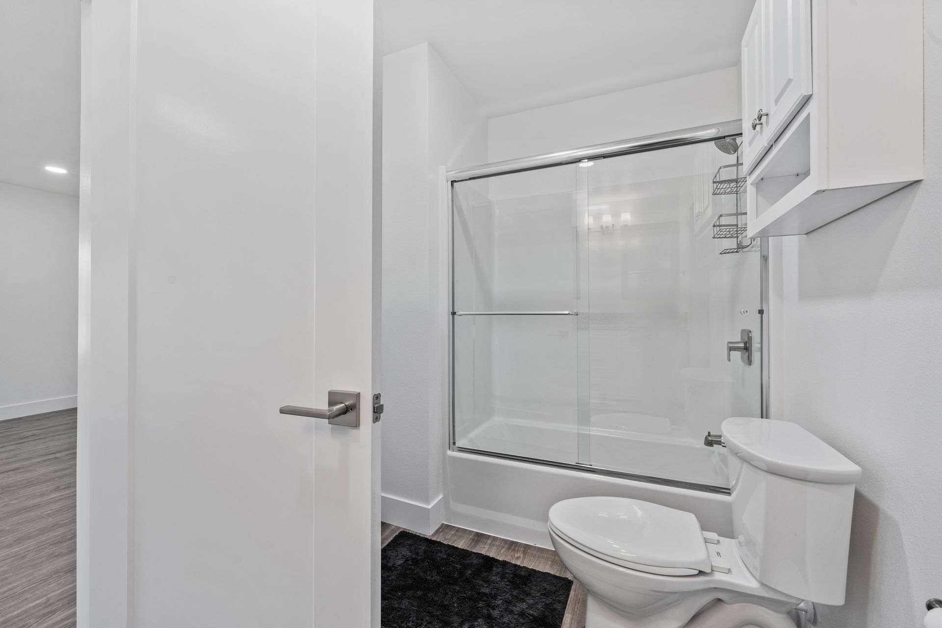 A bathroom with a toilet , shower and bathtub.