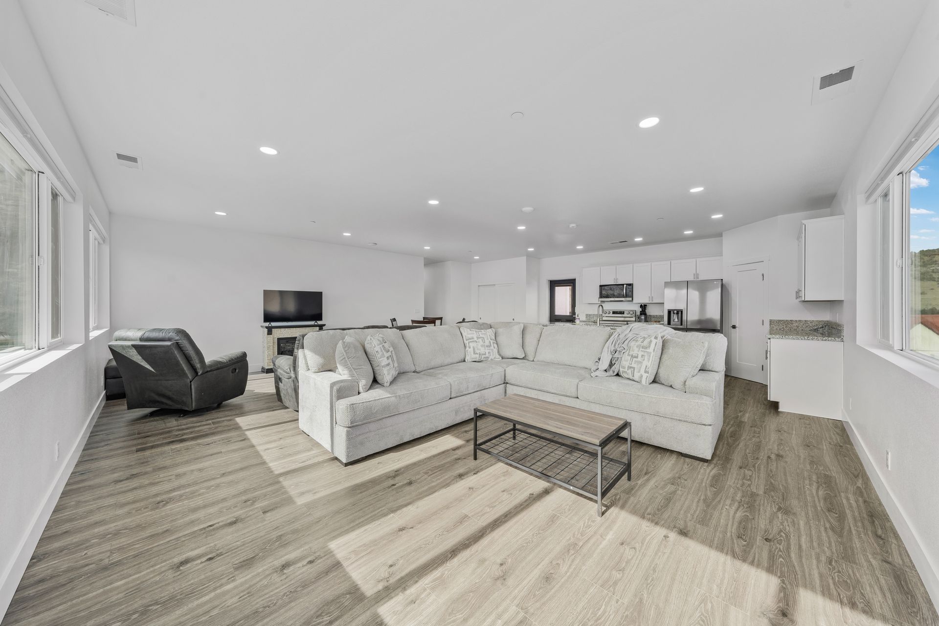 A living room with a couch , chair , coffee table and television.