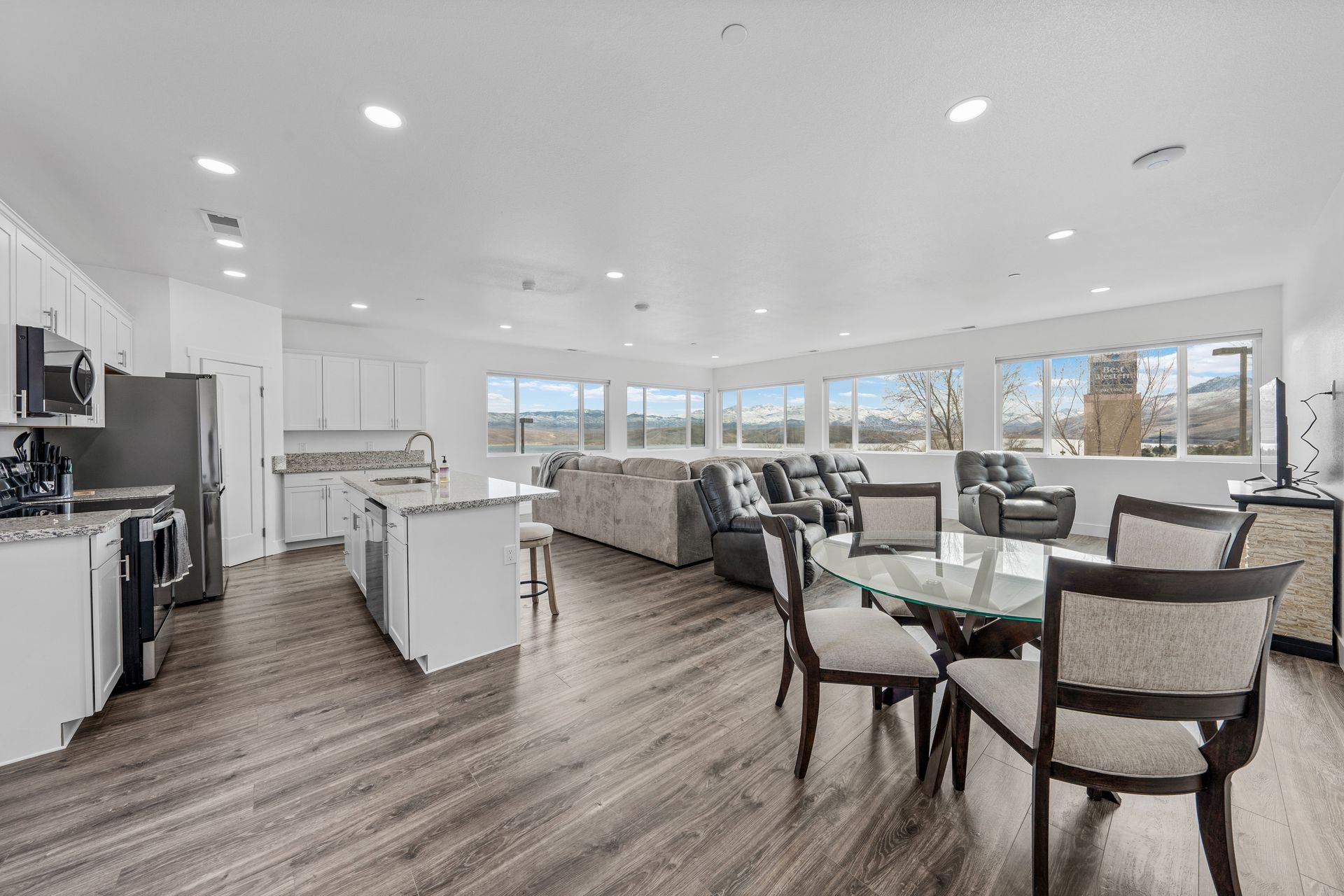 A large living room with a dining table and chairs and a kitchen.