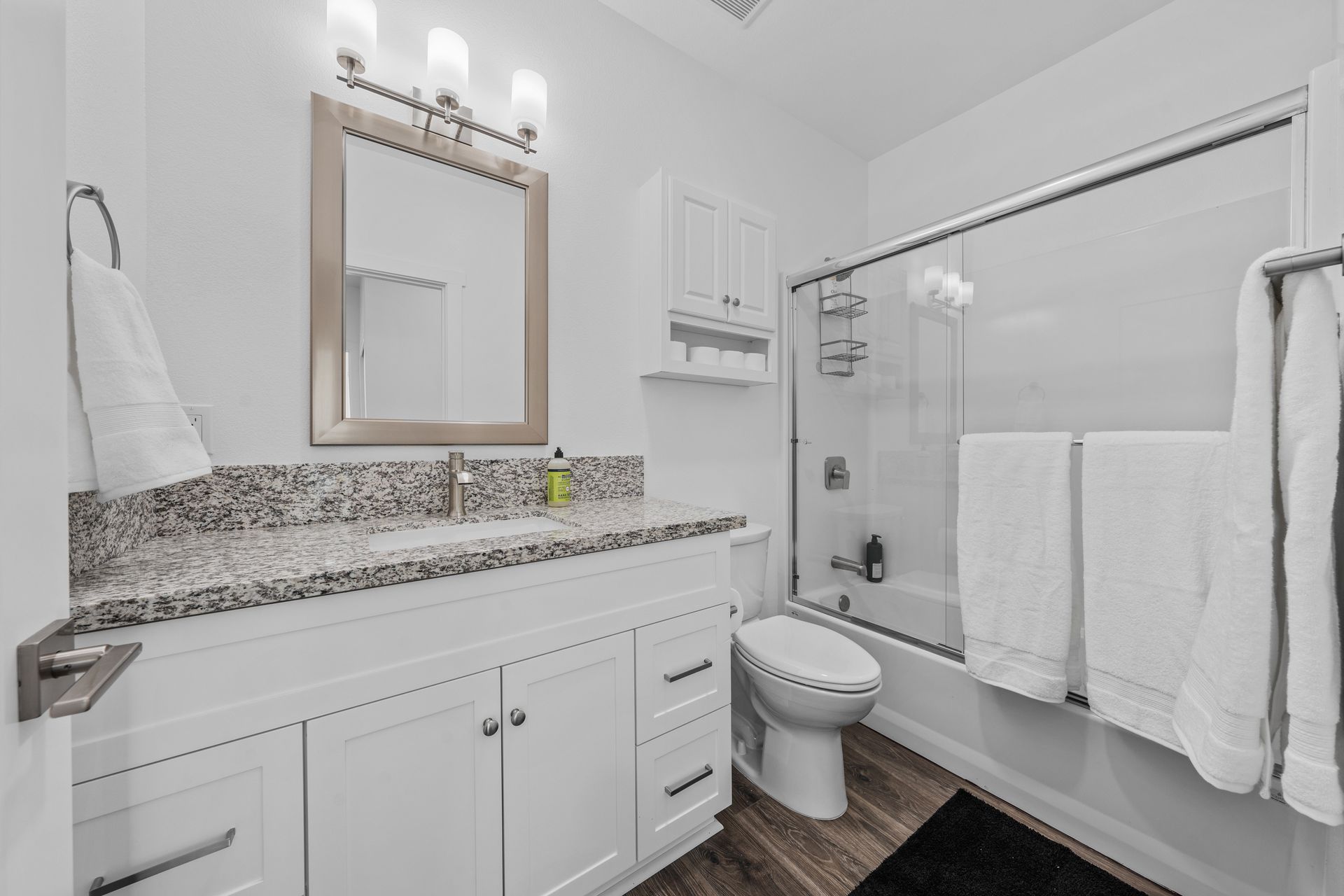 A bathroom with a toilet , sink , mirror and bathtub.