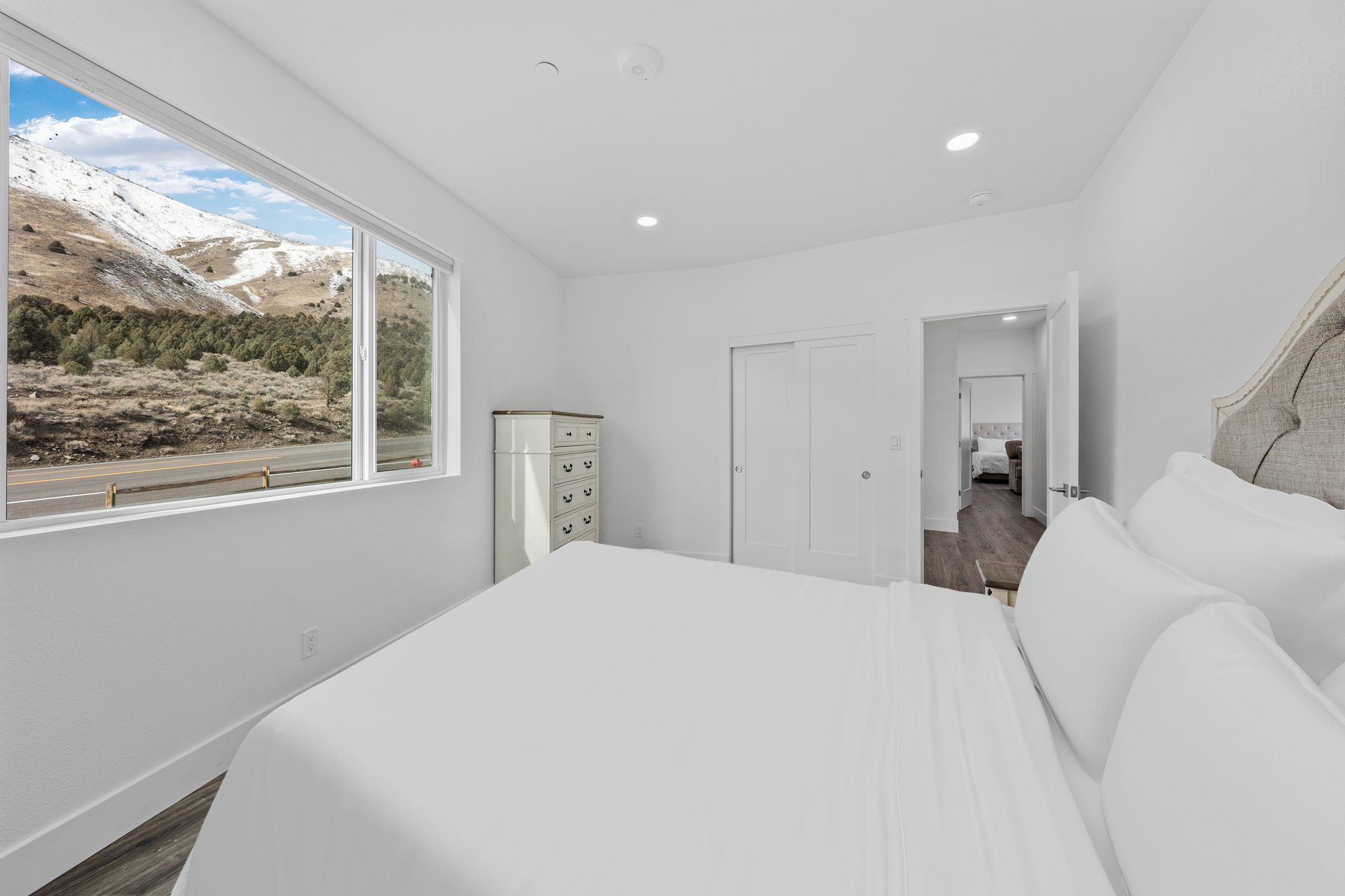 A bedroom with a bed and a window with a view of a mountain.