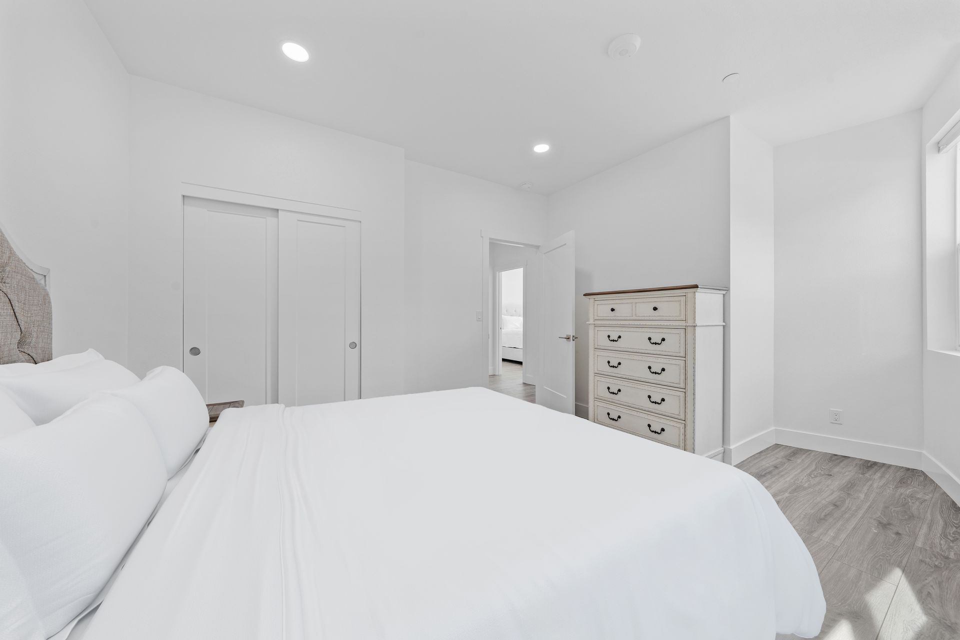 A bedroom with a king size bed , dresser , and closet.