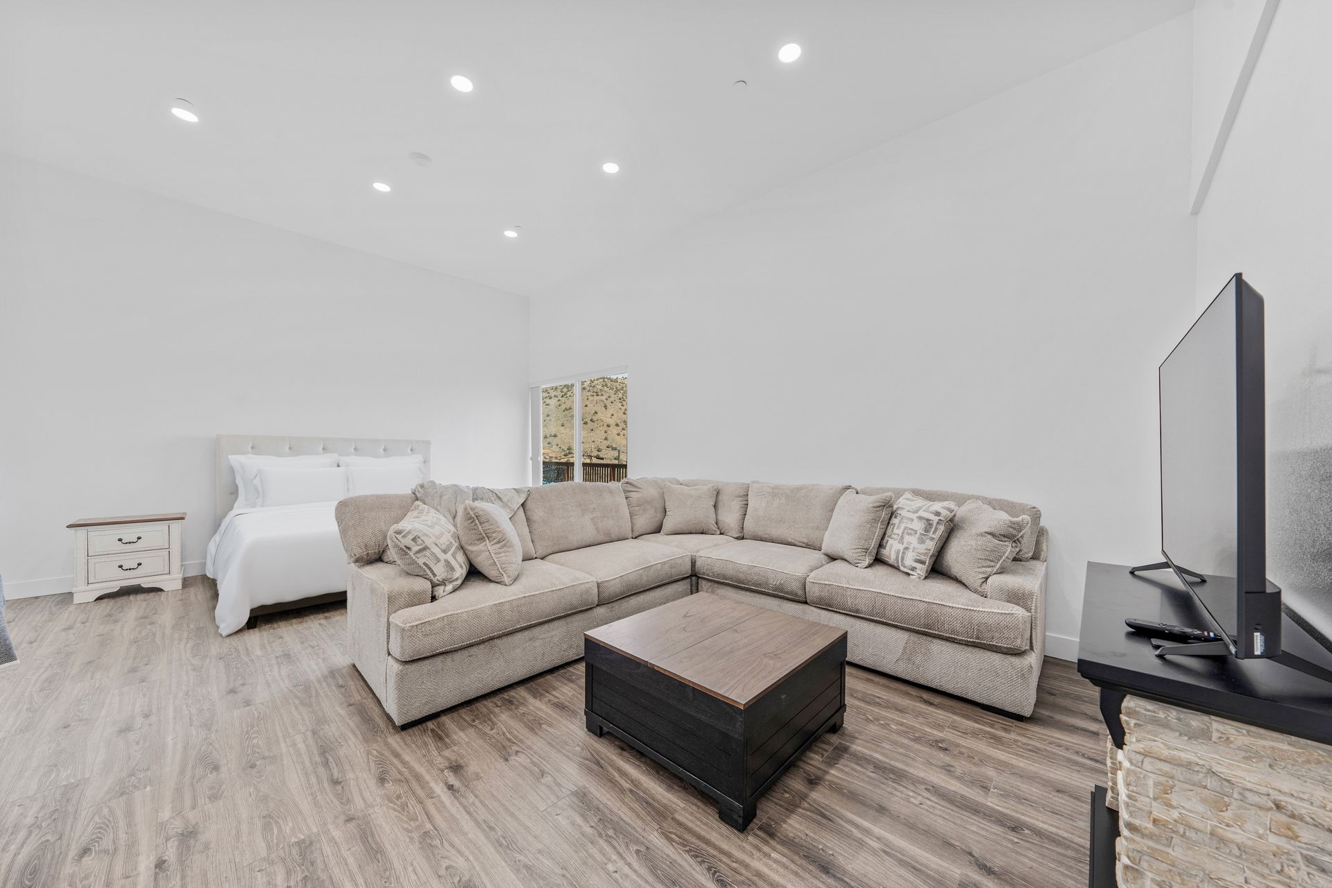 A living room with a large sectional couch and a flat screen tv.