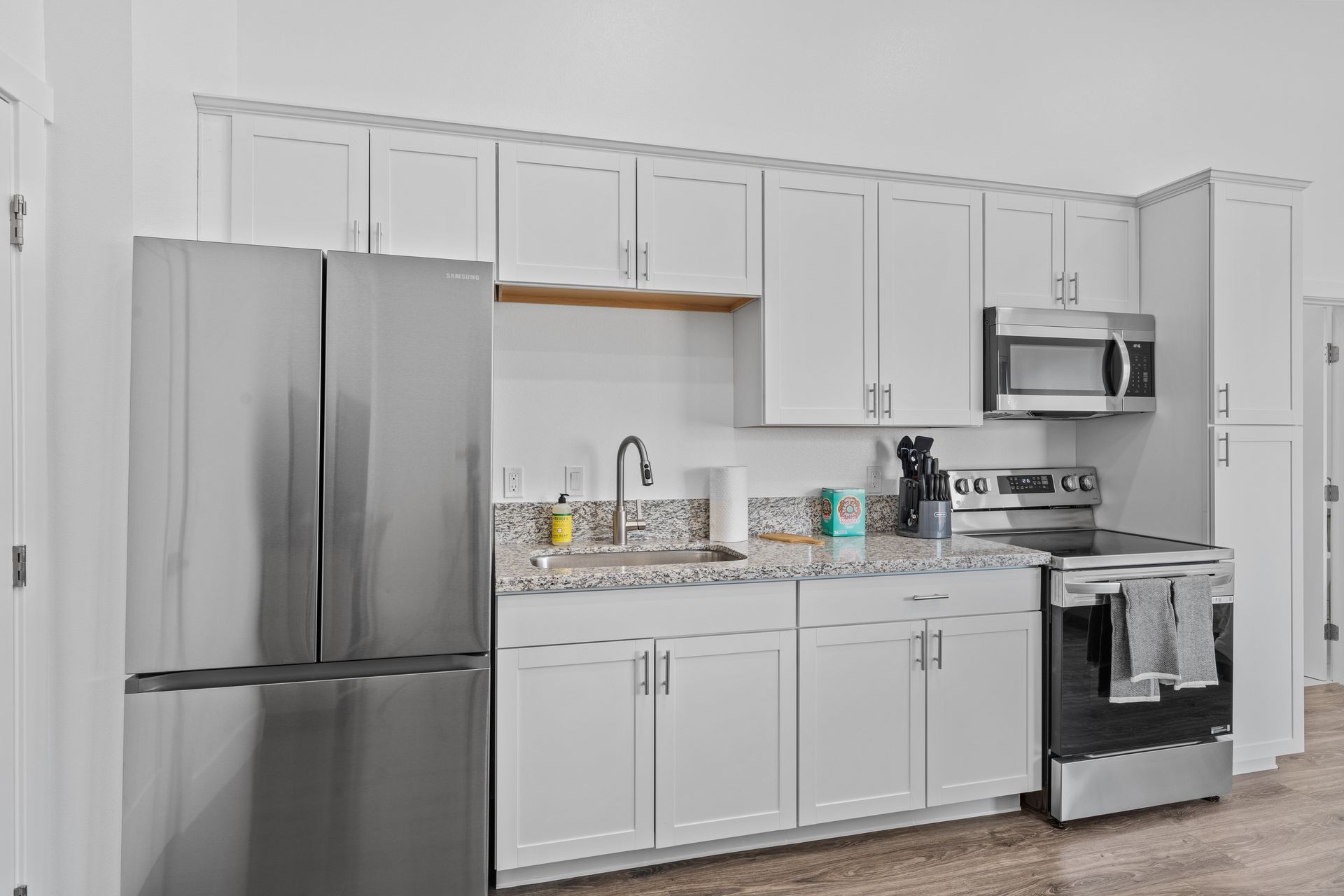 A kitchen with white cabinets and stainless steel appliances.