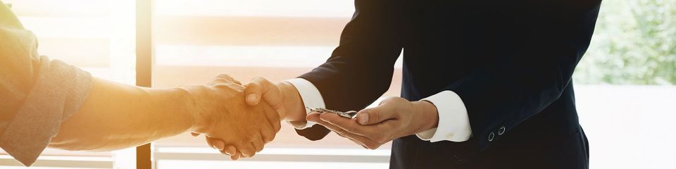 Real estate broker agent and customer shaking hands and give keys after signing contract documents for realty purchase, Bank employees congratulate, Concept mortgage loan approval.