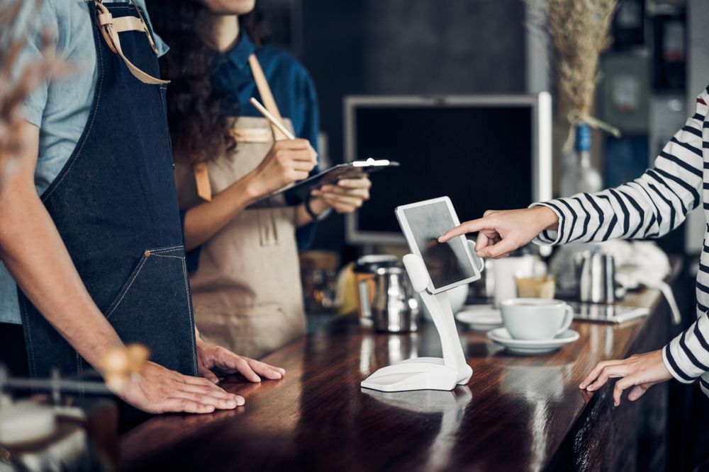 Customer Using Tablet to Pay at a Cafe Counter — Chefs2Go in Sunshine Coast, QLD