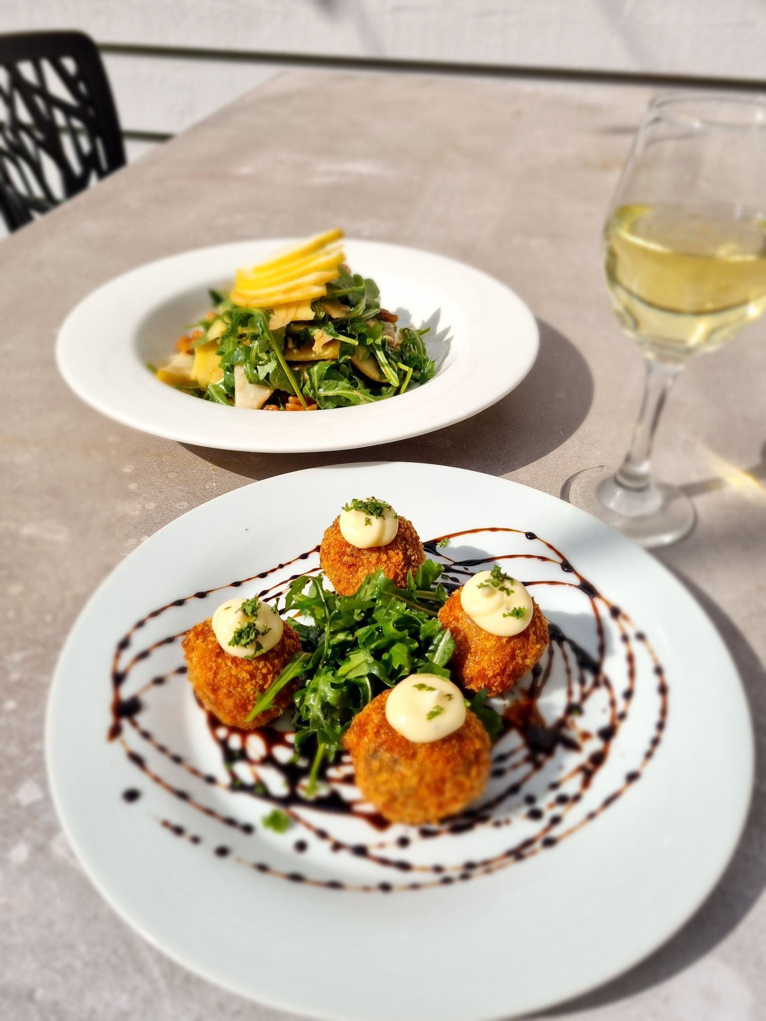 Plate of Food With Croquettes, Salad, and White Wine on a Table — Chefs2Go in Cairns, QLD