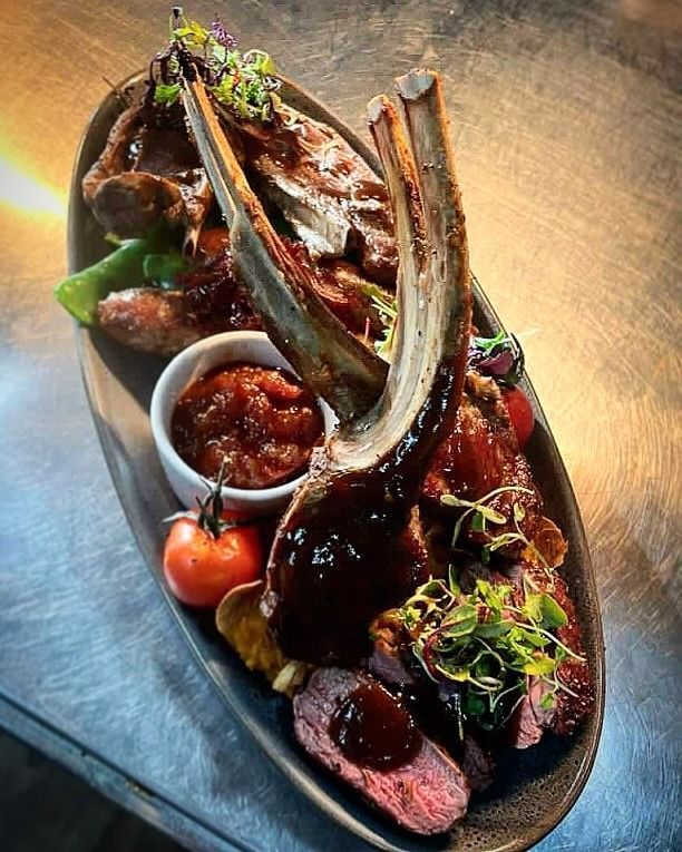 Platter of Cooked Meats, Including a Large Rib, With Sauce, Garnish, and a Small Dipping Bowl — Chefs2Go in Darwin, NT