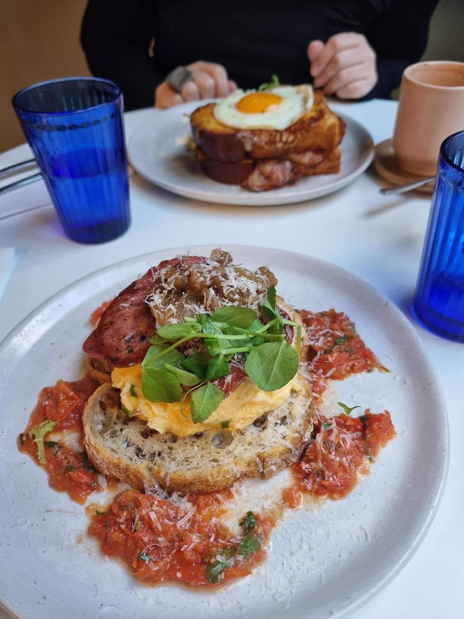 Two Plates of Food on a Table: One With Eggs, Bacon, and Sauce — Chefs2Go in Sunshine Coast, QLD
