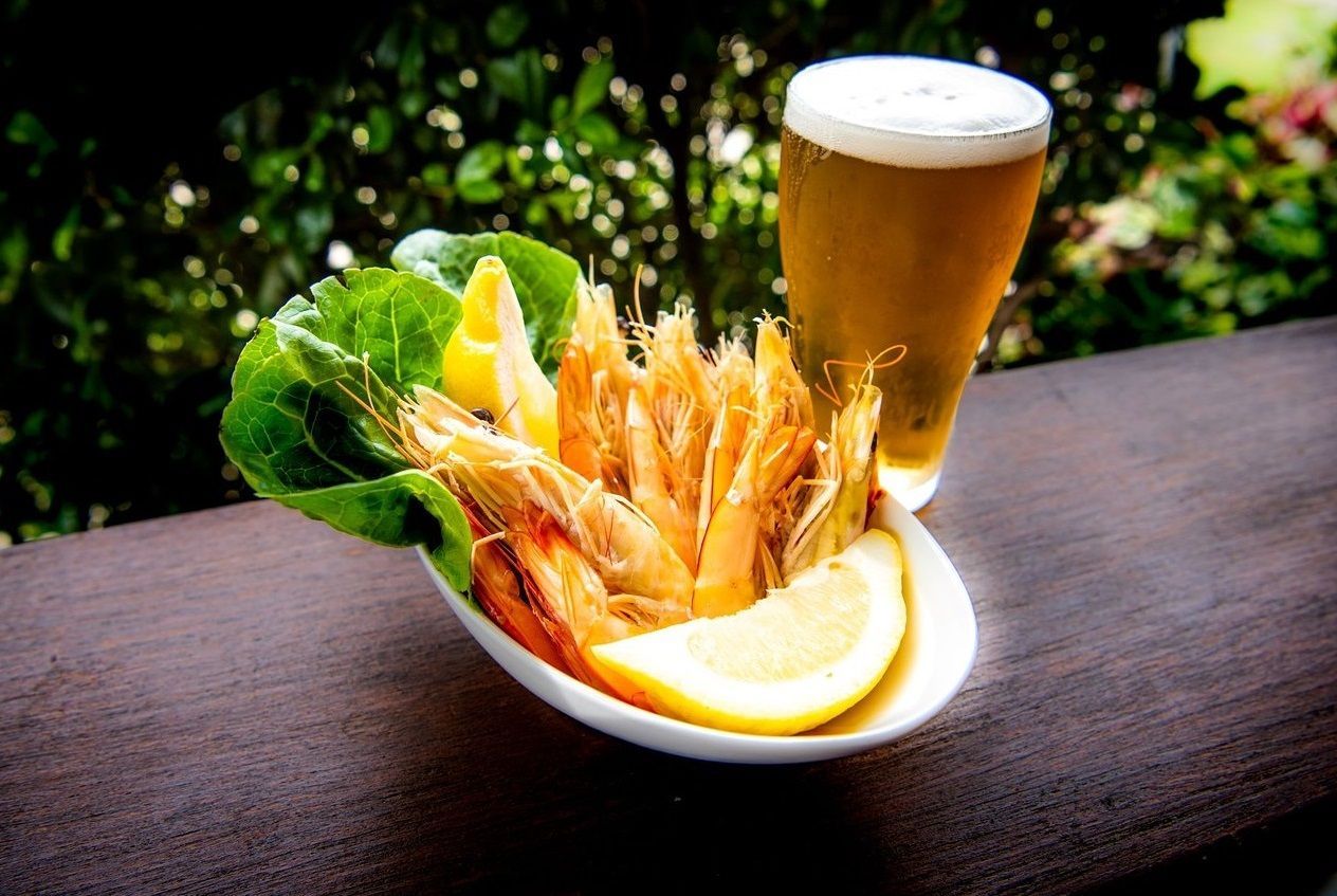 Fried Shrimp With Lemon and Beer on a Wooden Surface With a Green Background — Chefs2Go in Woodwark, QLD