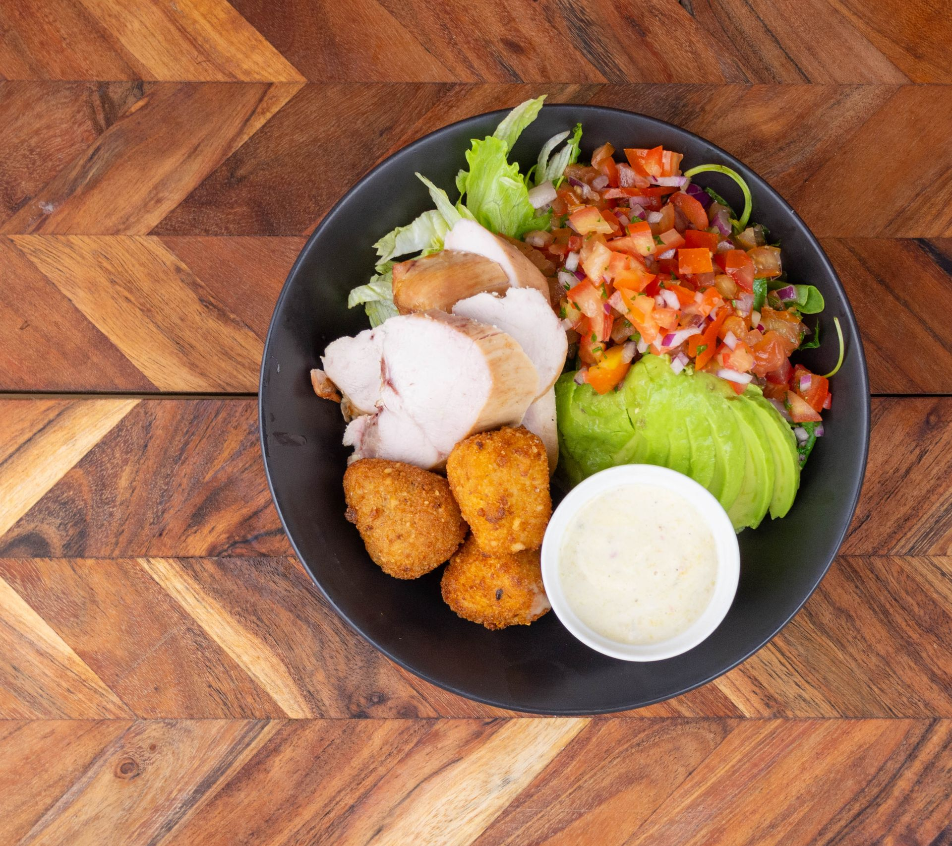 Chicken salad bowl with avocado, salsa, and sauce on a wooden table — Chefs2Go in Whitsunday, QLD