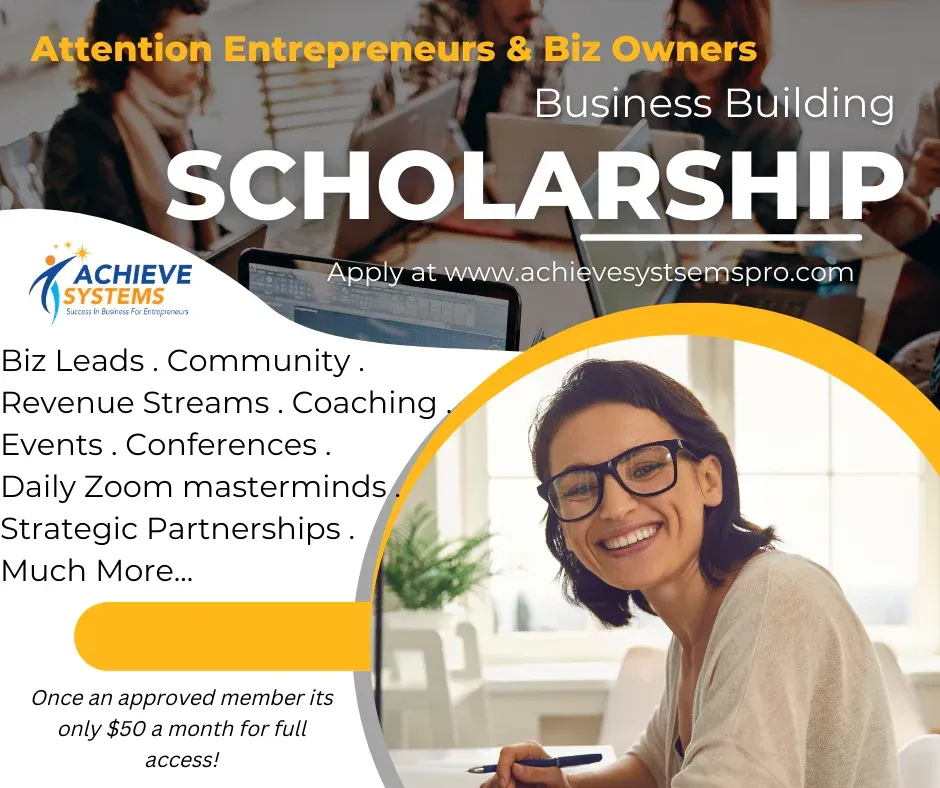 A woman is smiling while sitting at a desk in front of a laptop computer.