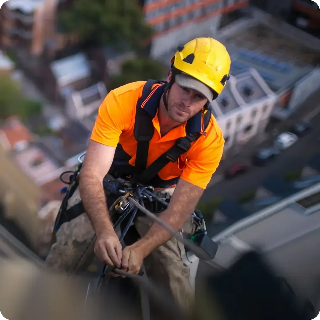 Un homme portant un casque jaune travaille sur une corde