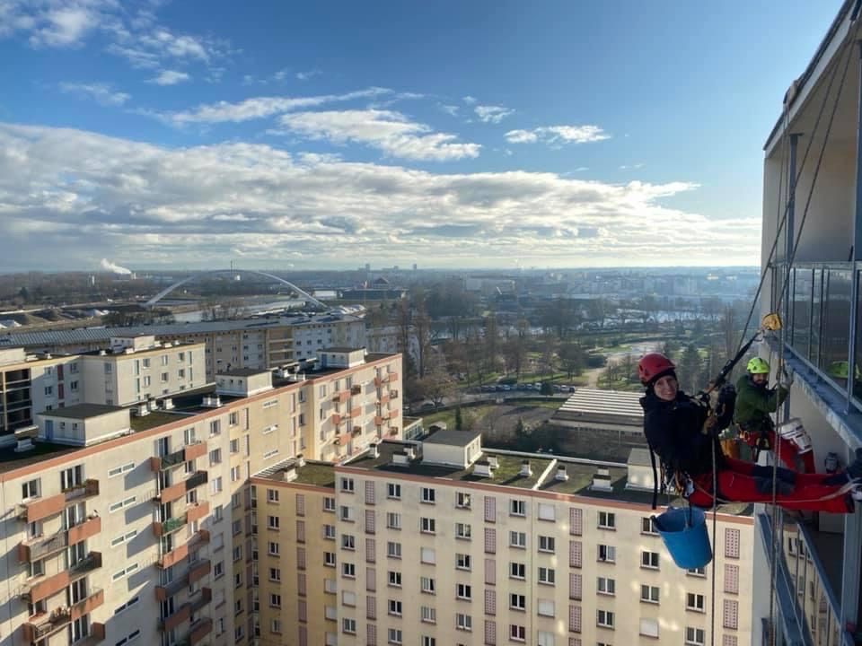 Un groupe de personnes grimpe sur le côté d'un grand bâtiment.