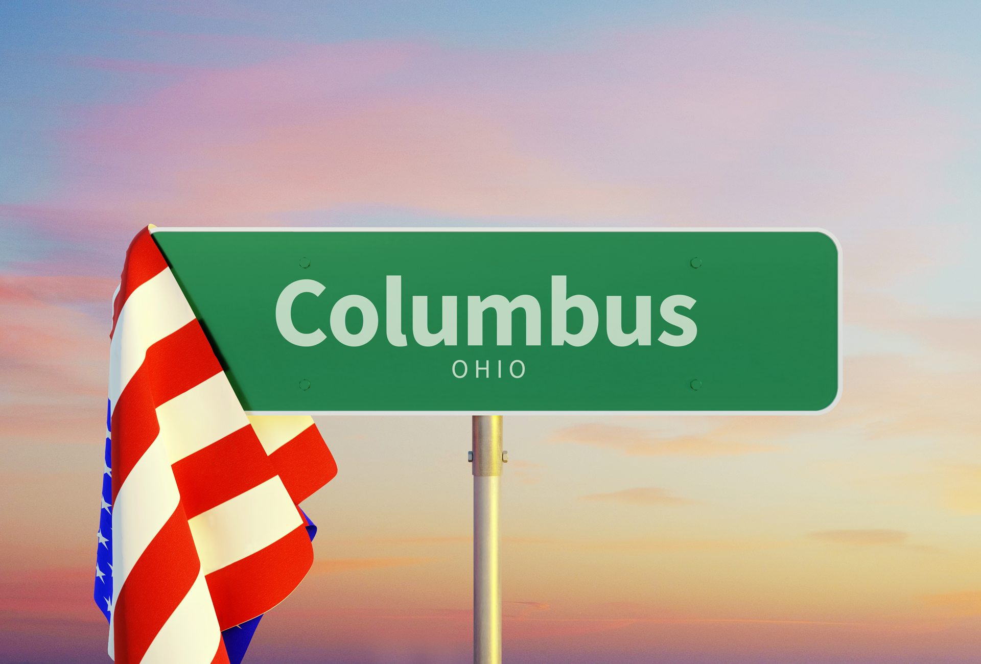 A green street sign for Columbus Ohio with an American flag